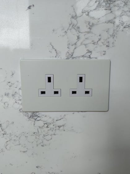 Screwless white double socket on marble kitchen island, June 2024.